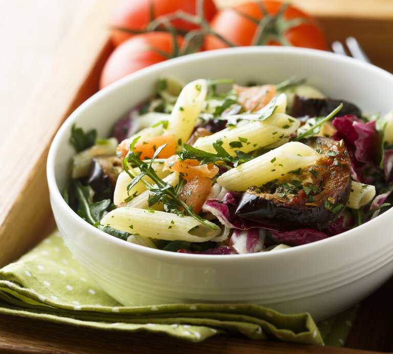 Eine Schüssel Nudelsalat mit Aubergine, Rucola und Minze. | © Shutterstock/ MariaKovaleva