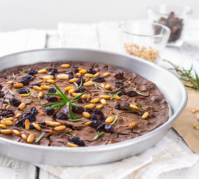 Eine weiße Platte mit toskanischem Kastanienmehlkuchen auf weißem Holztisch. | © Shutterstock / leonori