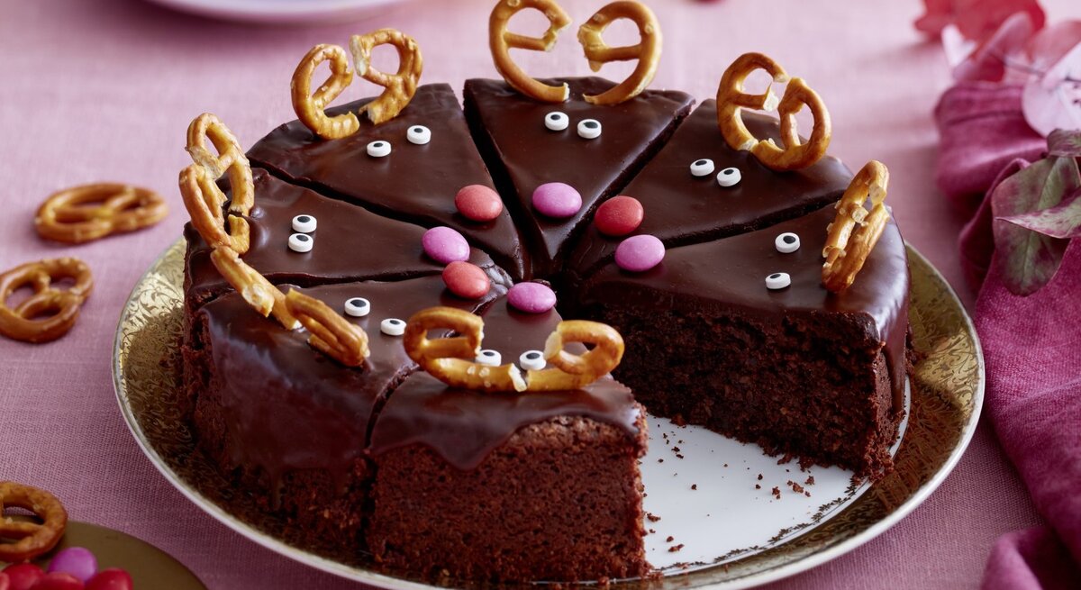Auf einem Teller liegt eine niedliche Rudolftorte. Sie ist mit Bretzeln und Zuckeraugen verziert.