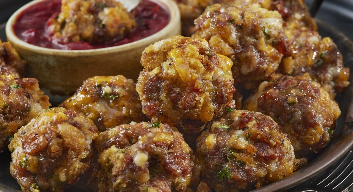 Knusprig gebackene Speck-Frikadellen aus dem Backofen mit rotem Dip.