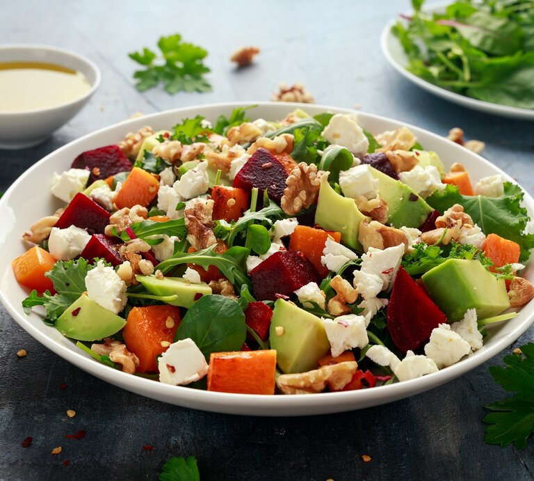 Ein weißer tiefer Teller mit einer Kürbis-Bowl mit Avocado und Feta. | © AdobeStock/grinchh