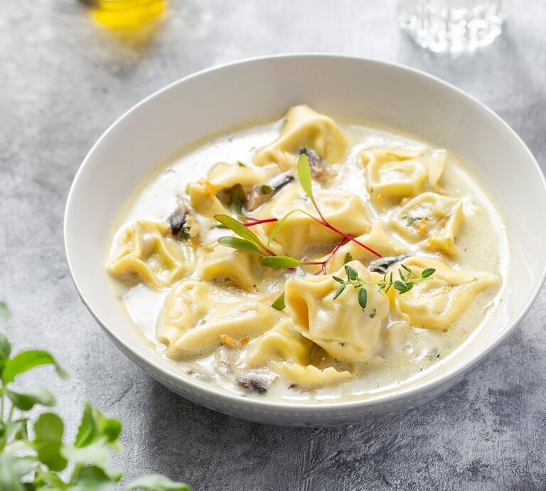 Eine weiße Schale mit der Suppe auf grauem Untergrund. Alles von schräg oben fotografiert. | © Shutterstock/ Pronina Marina