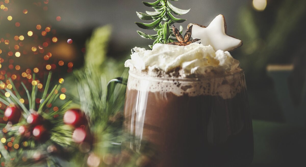 Weihnachtlich dekorierte heiße Schokolade in durchsichtigem Glas. 