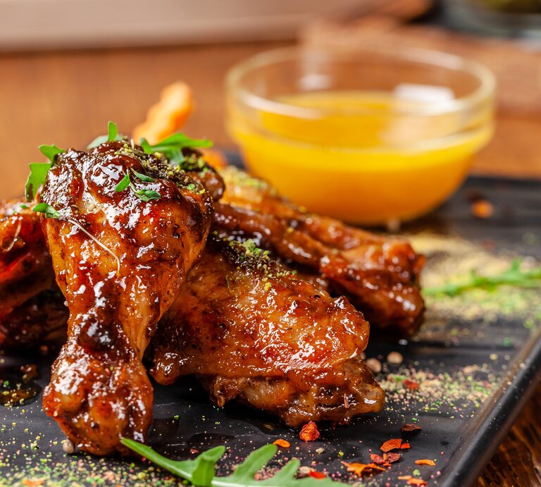 BBQ-Hähnchen in Rhabarber-Aprikosen-Marinade mir gelber Soße | © GettyImages/Zufar Kamilov
