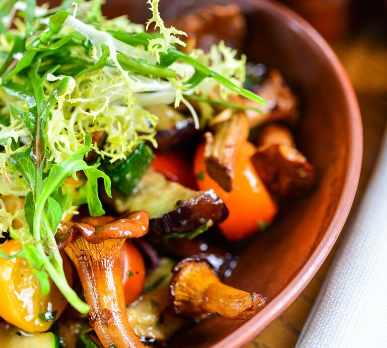 Eine braune Schale mit dem Salat auf einem dunklen Holztisch sehr nah dran fotografiert. | © Shutterstock/ kravastudio