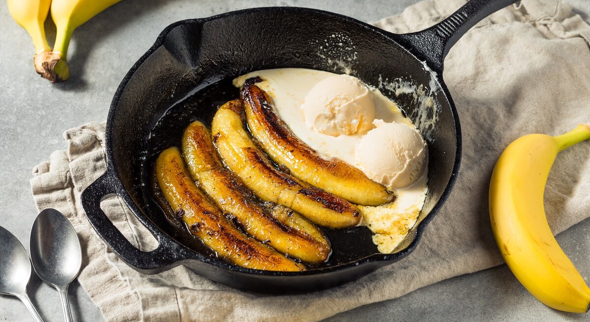 Eine Pfanne mit Rum-Bananen mit Vanilleeis.