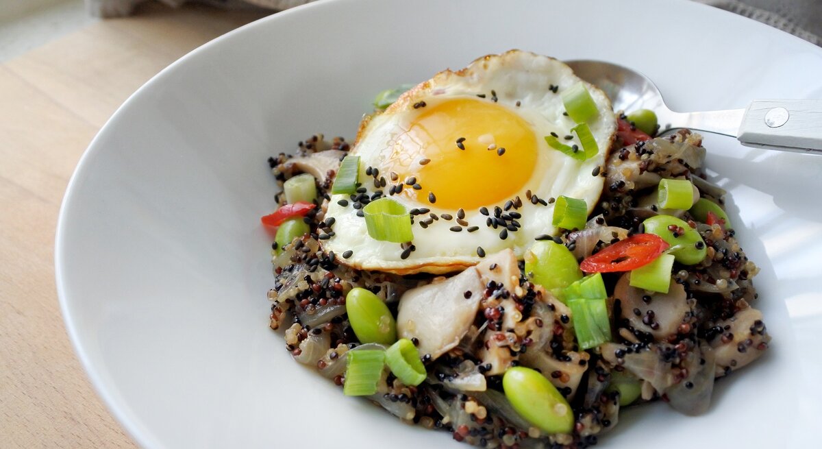 Eine Portion asiatische Quinoa-Bowl in einer weißen Schüssel.