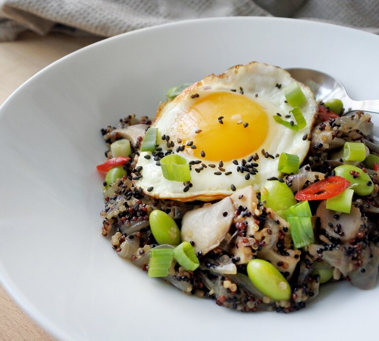Eine Portion asiatische Quinoa-Bowl in einer weißen Schüssel. | © Shutterstock/kokofoundit