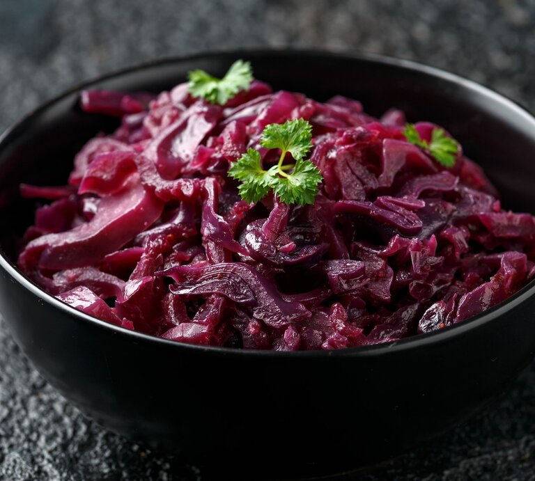 Eine schwarze Schale mit Rotkohl auf einem dunklen Tisch. | © Gettyimages/ DronG