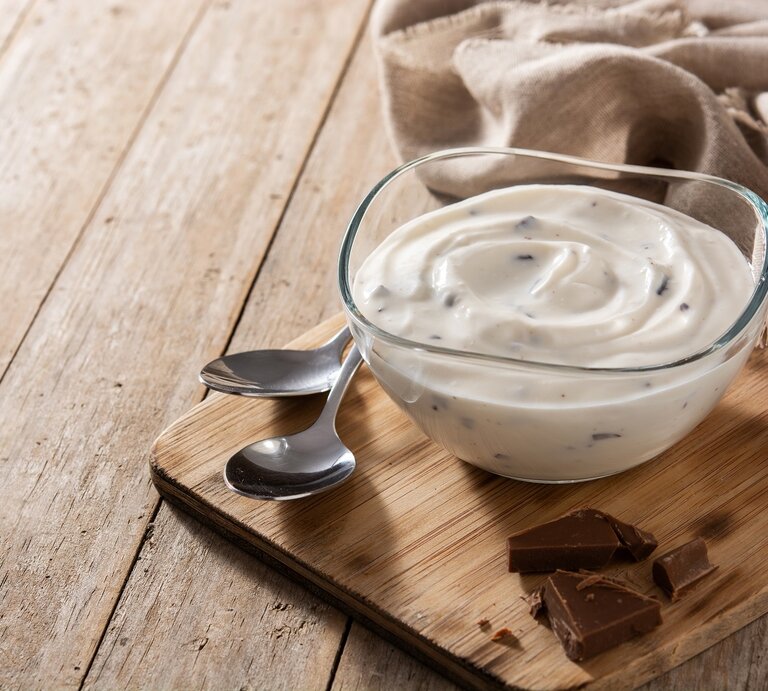Ein Glas Herrencreme auf einem Holzbrett neben zwei Löffeln. | © AdobeStock/chandlervid85