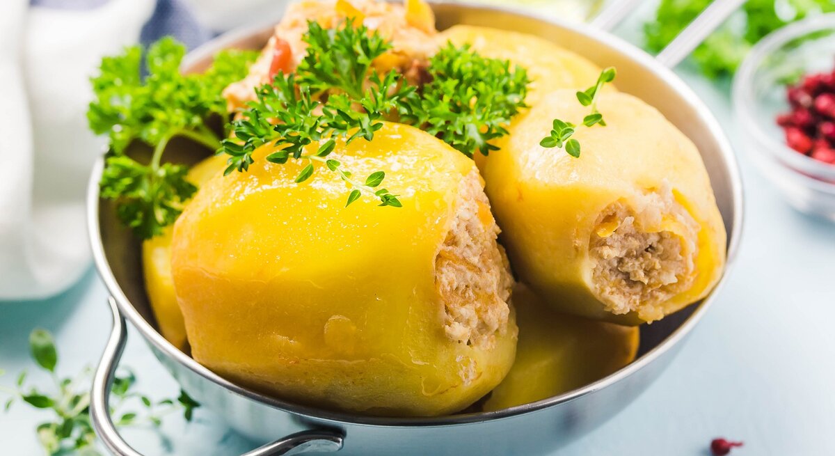 3 gefüllte Kartoffeln Batata Mahshieh in einer Metallschale, mit Petersilie bestreut, drumherum unscharf Zutaten.