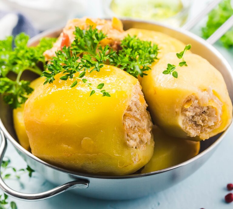 3 gefüllte Kartoffeln Batata Mahshieh in einer Metallschale, mit Petersilie bestreut, drumherum unscharf Zutaten. | © Shutterstock/ Irina Rostokina
