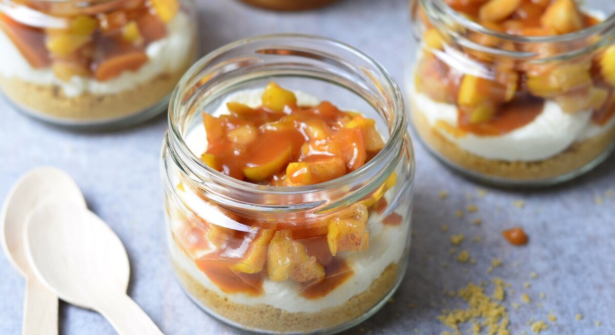 Mehrere Dessertgläser mit dem Schichtdessert auf einem hellgrauen Untergrund von schräg oben fotografiert.