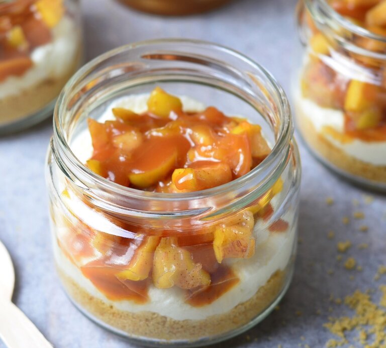 Mehrere Dessertgläser mit dem Schichtdessert auf einem hellgrauen Untergrund von schräg oben fotografiert. | © Shutterstock/ Julie208