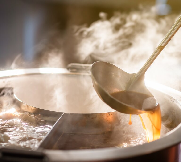 Auf dem Herd steht ein Topf voller dampfender Suppe.  | © AdobeStock/pop_thailand