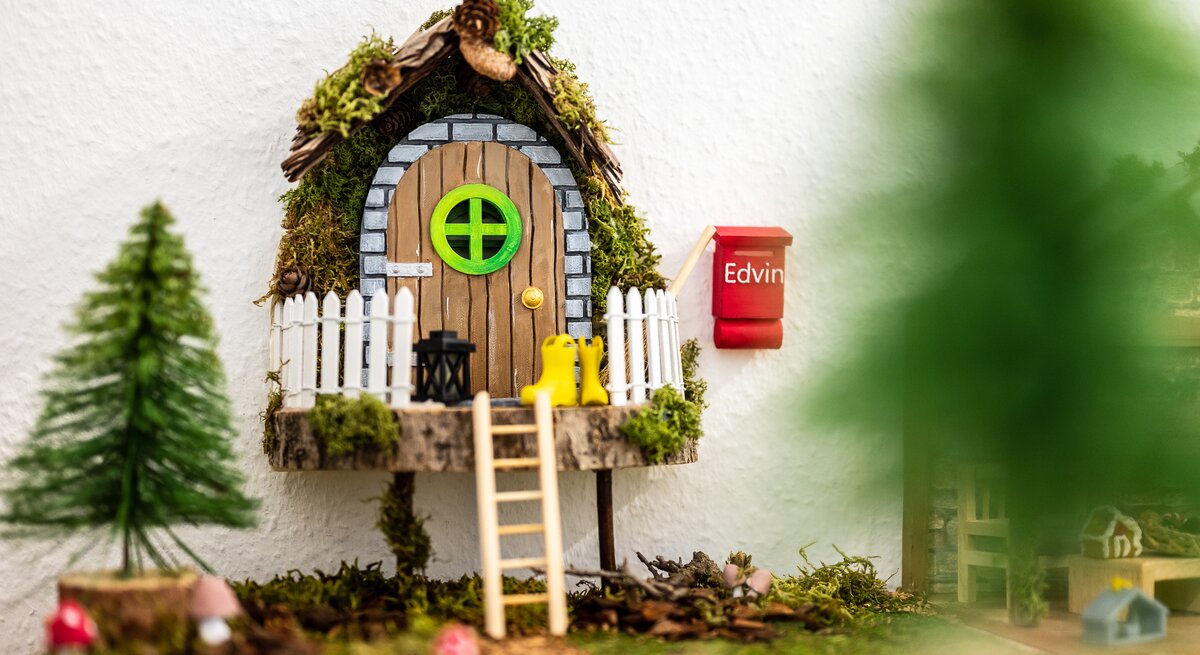 Ein selbst gebastelte Wichteltür mit Briefkasten, Tannenbaum und Leiter. 
