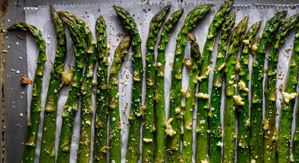 Grüner Spargel auf einem Backblech direkt von oben fotografiert.