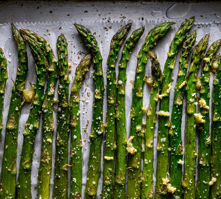 Grüner Spargel auf einem Backblech direkt von oben fotografiert. | © Shutterstock/ P Kyriakos
