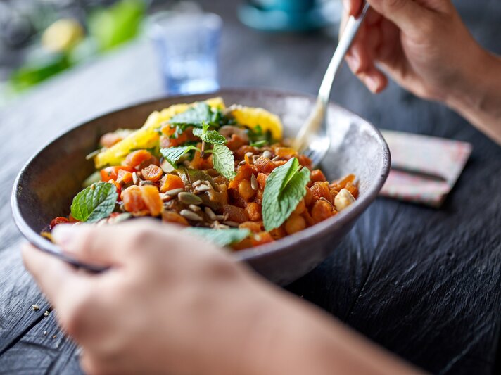 Ein leckerer Salat aus roten Linsen, Tomaten, Kürbiskernen und etwas Minze.  | © GettyImages/julief514