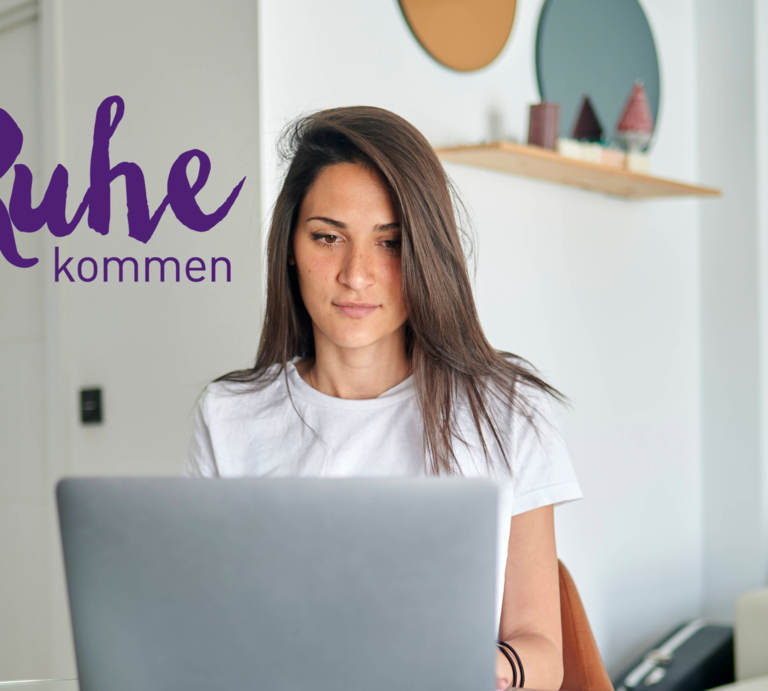 Eine junge Frau sitzt konzentriert an einem gläsernen Tisch und arbeitet an ihrem Laptop. Sie trägt ein weißes T-Shirt und hat lange dunkle Haare. Im Hintergrund ist ein modern eingerichtetes Zimmer mit hellen Wänden und zeitgenössischer Dekoration zu sehen. Auf dem Laptop ist der Schriftzug "#zur Ruhe kommen" zu sehen. | © IMAGO / Westend61