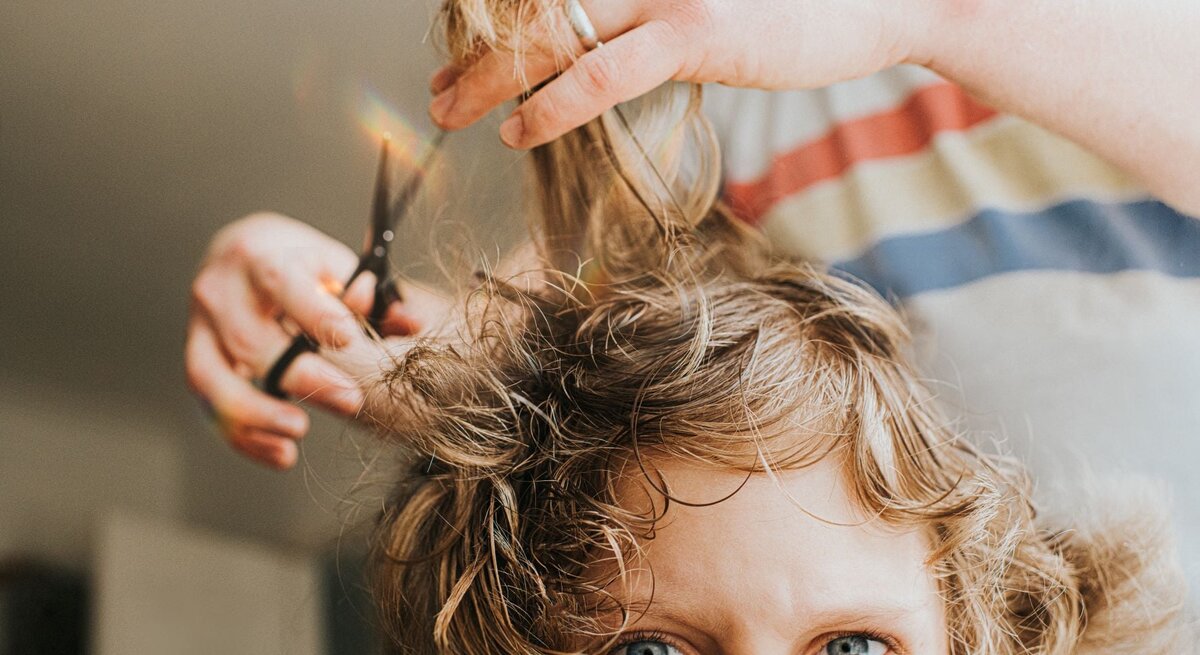 Einer jungen Frau werden die Haare geschnitten
