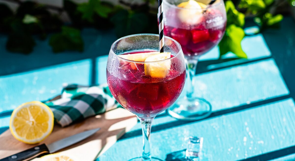 Zwei Gläser spanische Rotwein-Limonade auf einem blauen Tisch.