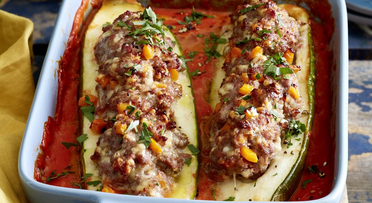 In einer Auflaufform ist gefüllte Schmorgurken angerichtet. Sie ist mit Hackfleisch gefüllt.