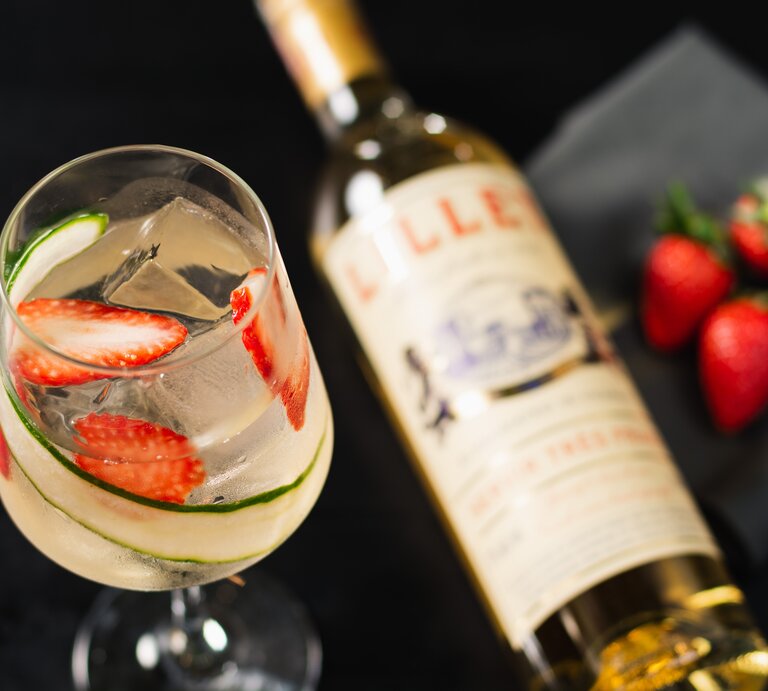 Lillet Gin Tonic in Weinglas mit Lillet-Flasche und Erdbeeren. Draufsicht. | © shutterstock / Fernanda Flugel