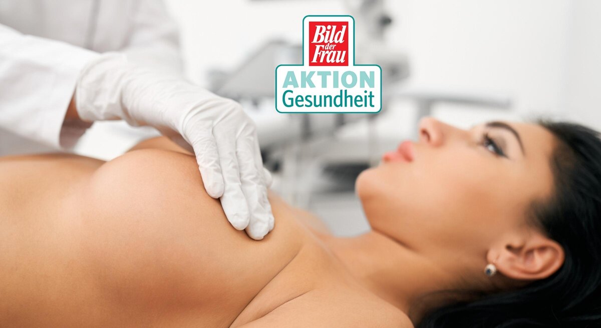 Eine Frau wird von einem Arzt oder einer Ärztin, die Einweghandschuhe trägt, auf Brusterkrankungen untersucht. Die Frau liegt zurückgelehnt, und ihre Brust wird vorsichtig abgetastet, was auf eine routinemäßige klinische Untersuchung hinweist. Das "Bild der Frau AKTION Gesundheit" Logo im Bild betont die Wichtigkeit von regelmäßigen Gesundheitschecks und Bewusstsein für Brustgesundheit. Der Fokus und die entspannte Haltung der Frau deuten auf das Vertrauen in die medizinische Versorgung hin.