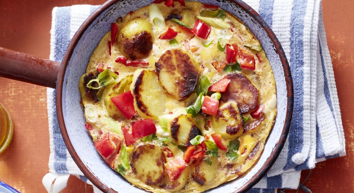  Tortilla mit Paprika und Kartoffeln in einer Pfanne / Küchentuch / Draufsicht
