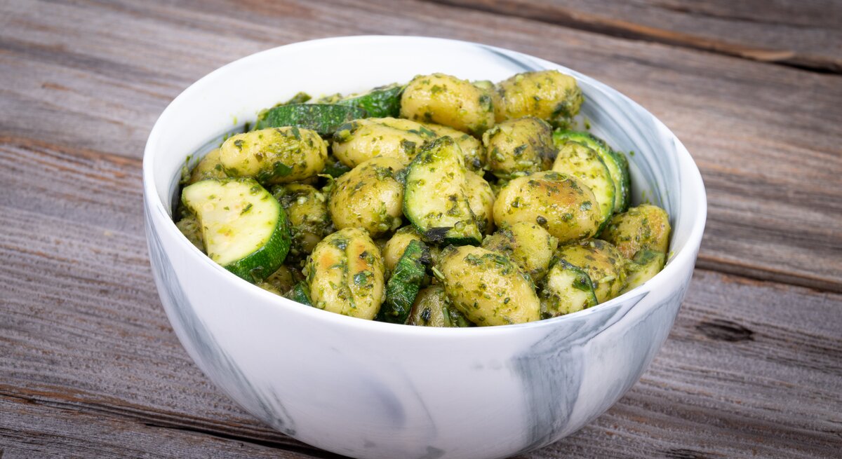 Eine Schale Gnocchi-Zucchini-Salat steht auf einem Tisch