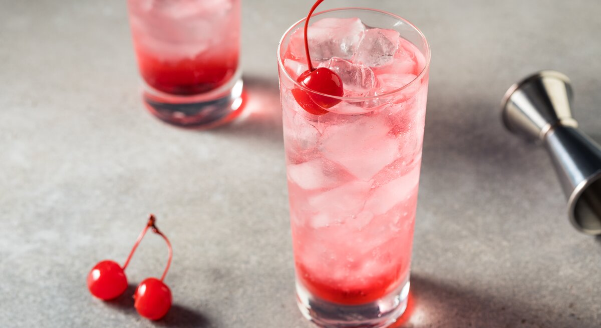 Zwei Gläser mit Dirty Shirley, verziert mit einer Cocktail-Kirsche. 