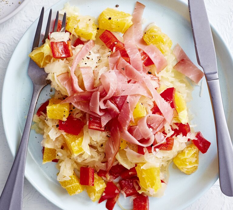 Sauerkrautsalat mit Orange und Schinken auf Teller angerichtet. | © EAT CLUB/ Isabell Triemer