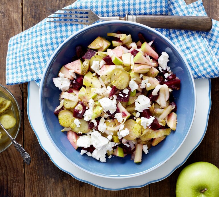 Rote-Bete-Salat mit Schafskäse, Apfelstücken und sauren Gurken, serviert in einer großen Schale auf einem Küchentuch.  | © EAT CLUB / Isabell Triemer