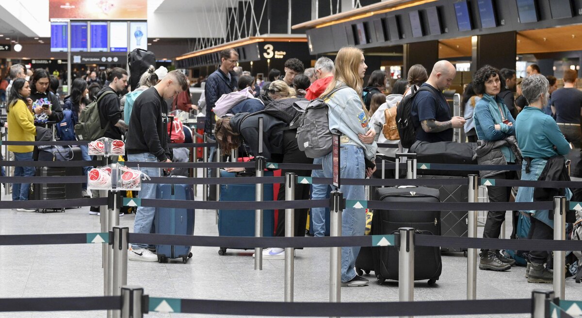 Passagiere beim Check-in Schalter in Zürich am Flughafen.