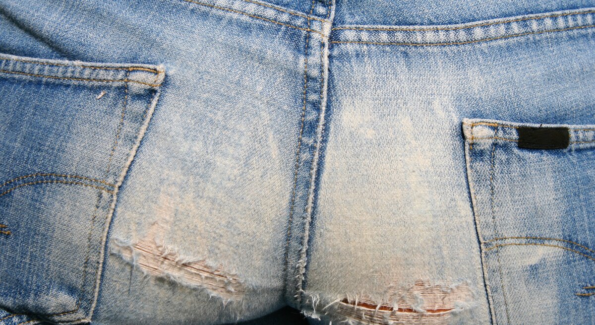 Eine Jeans von hinten, die am Gesäß gerissen ist