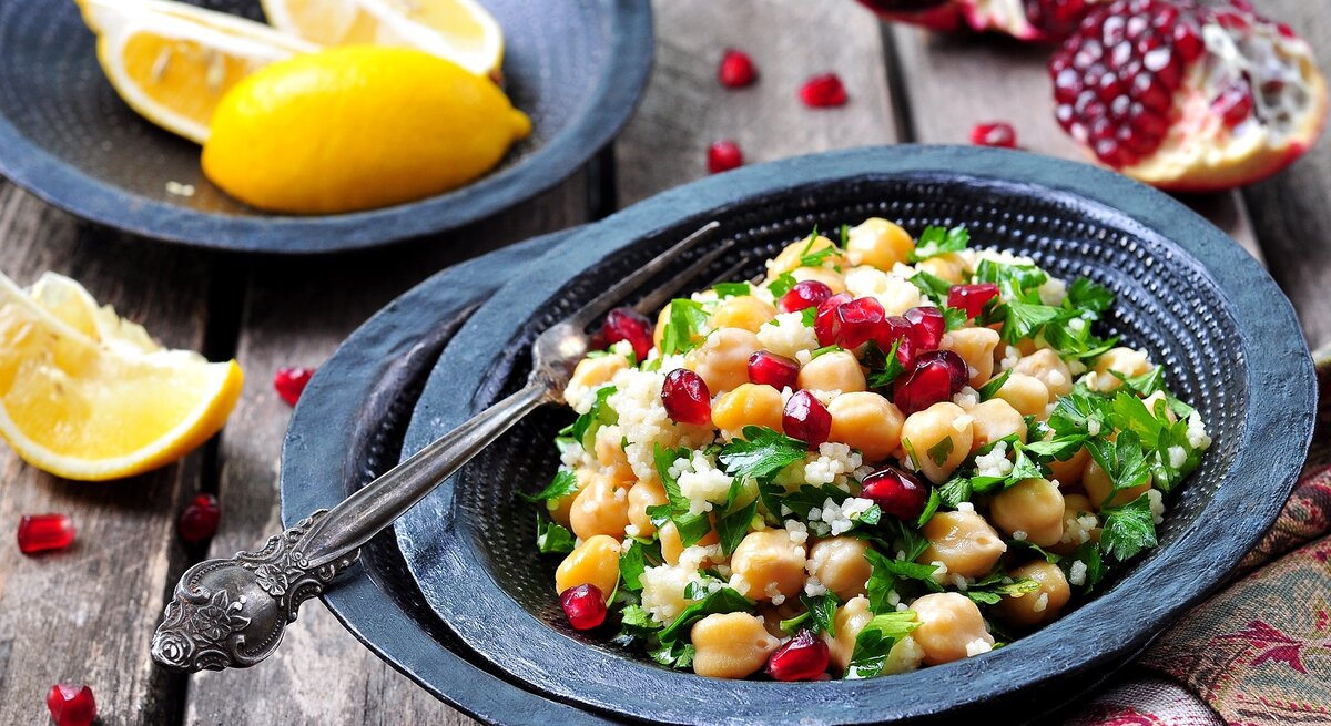 Ein Teller mit Couscous mit Granatapfel und Kichererbsen.