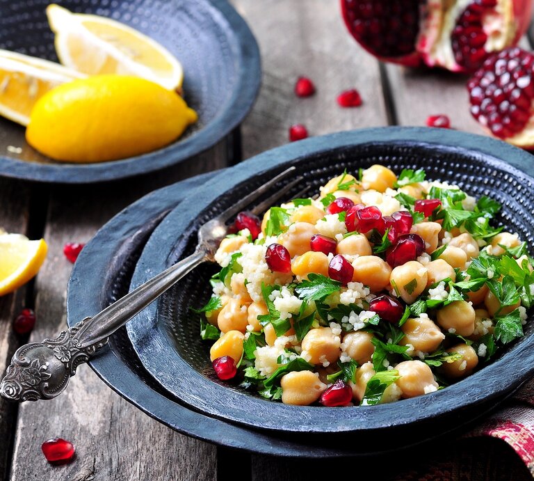 Ein Teller mit Couscous mit Granatapfel und Kichererbsen. | © Shutterstock/chudo2307