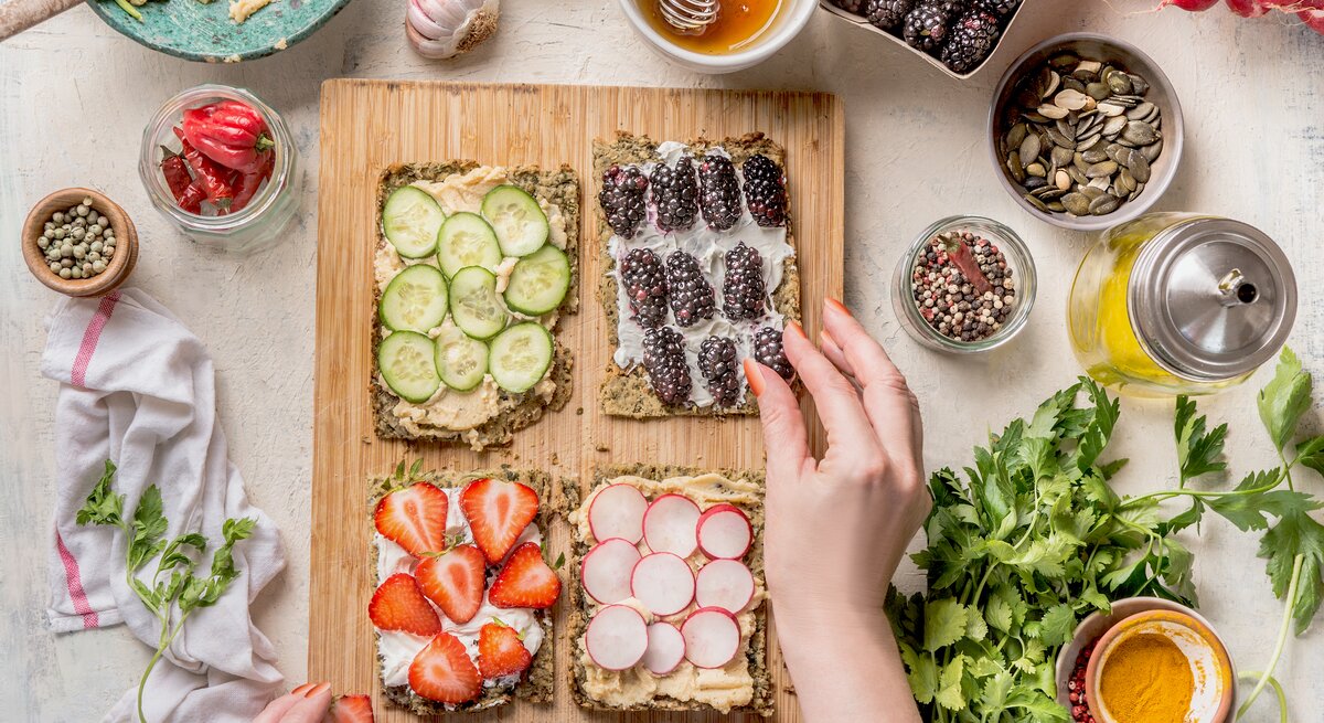 Tisch mit frischem Gemüse, Obst und Hummus