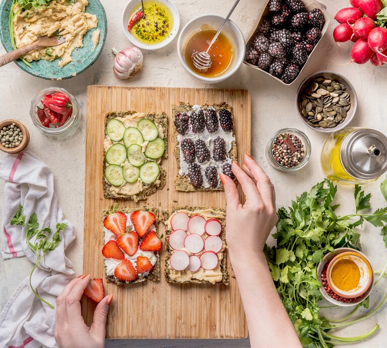 Tisch mit frischem Gemüse, Obst und Hummus | © Getty Images/VICUSCHKA