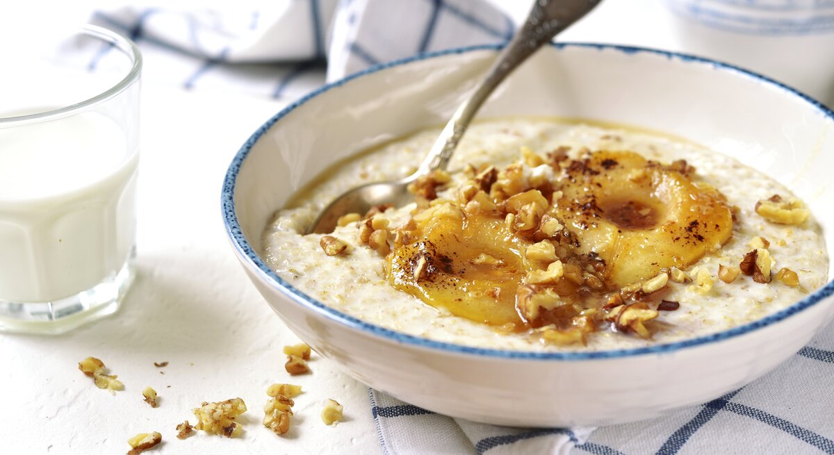 Eine weiße Schüssel mit Vanille-Porridge mit karamellisierten Birnen.