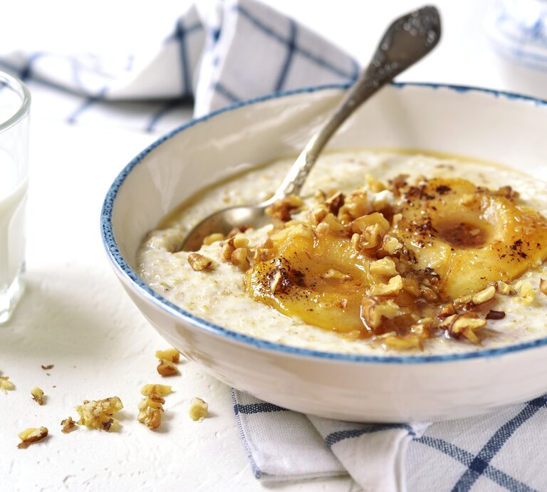 Eine weiße Schüssel mit Vanille-Porridge mit karamellisierten Birnen. | © GettyImages/Lilechka75