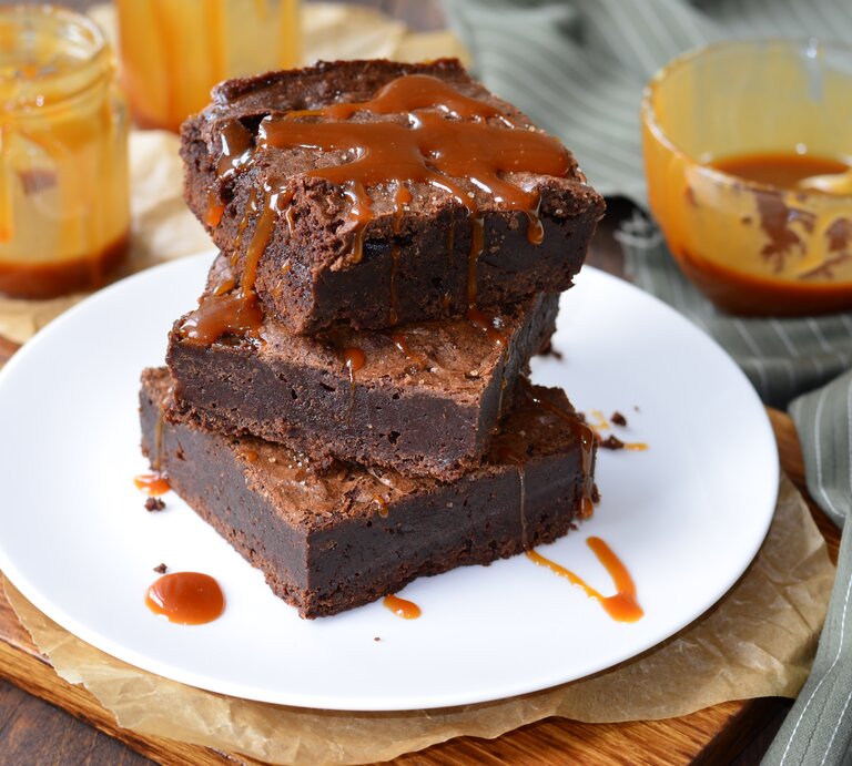 Ein Teller mit Salzkaramell-Brownies auf einem Holzbrett. | © Shutterstock/Julie208