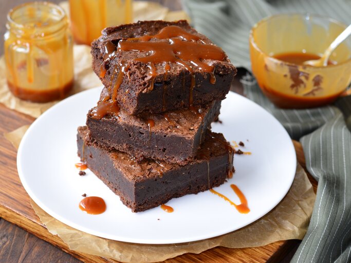 Ein Teller mit Salzkaramell-Brownies auf einem Holzbrett. | © Shutterstock/Julie208