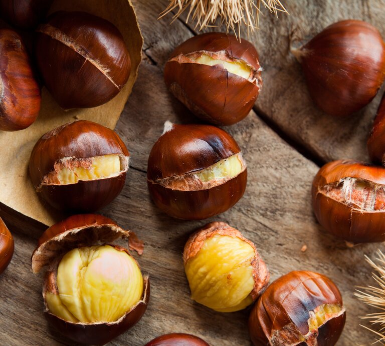 mehrere Kastanien auf Holz. | © iStock/joannatkaczuk