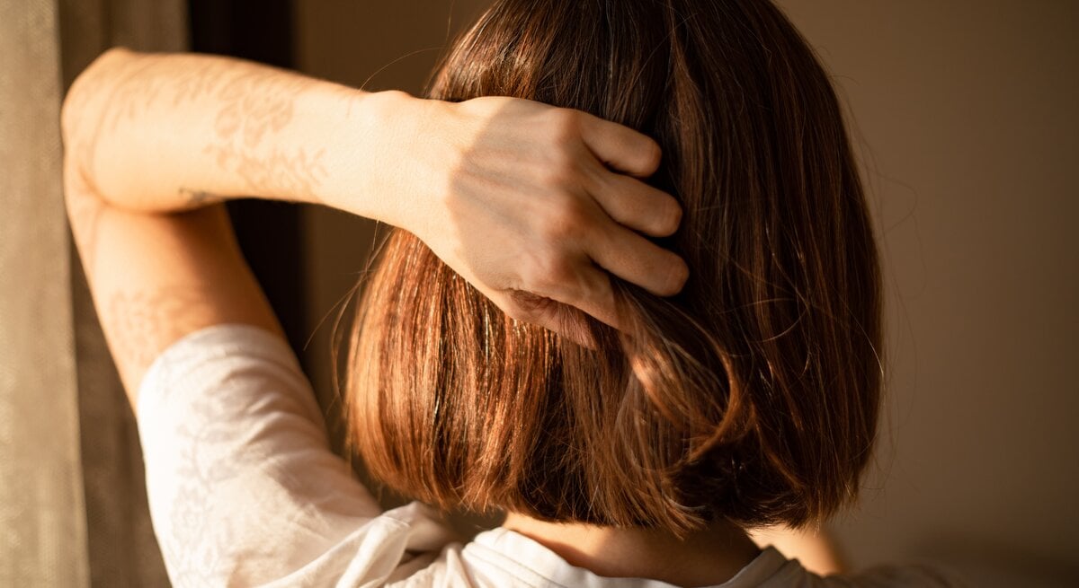 Eine Frau fasst sich in die Haare.