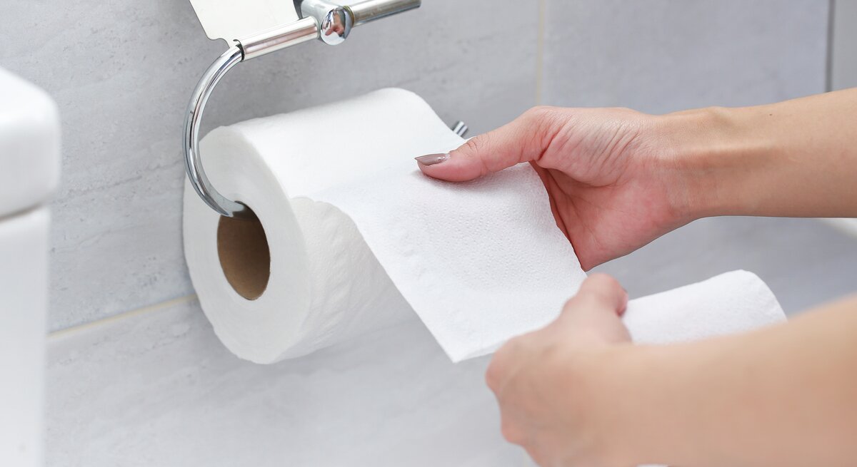 Eine Rolle Toilettenpapier im Halter an der Wand.