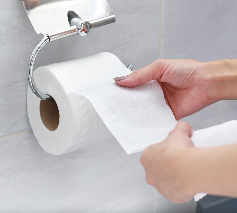 Eine Rolle Toilettenpapier im Halter an der Wand. | © Getty Images / Chakrapong Worathat / EyeEm