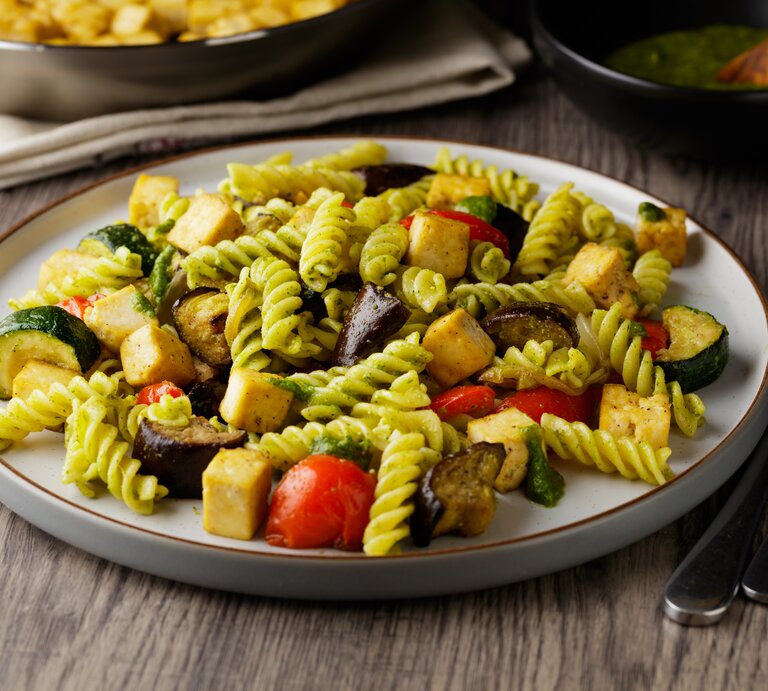 Pasta mit Pesto, gegrilltem Gemüse und Tofu auf weißem Teller | © Getty Images/haoliang