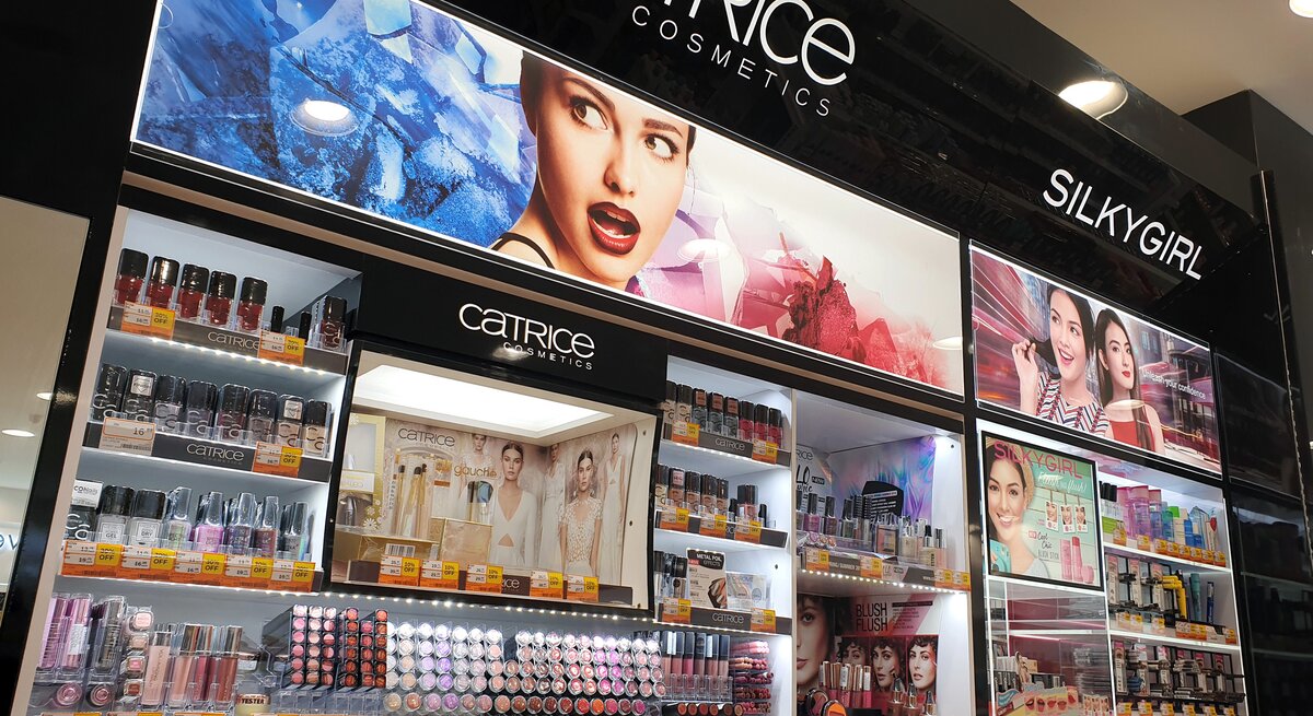 Kosmetikladen-Display, das eine Vielzahl von Produkten der Marken Catrice Cosmetics und SilkyGirl präsentiert. Die Produkte sind übersichtlich auf mehreren Regalen angeordnet.